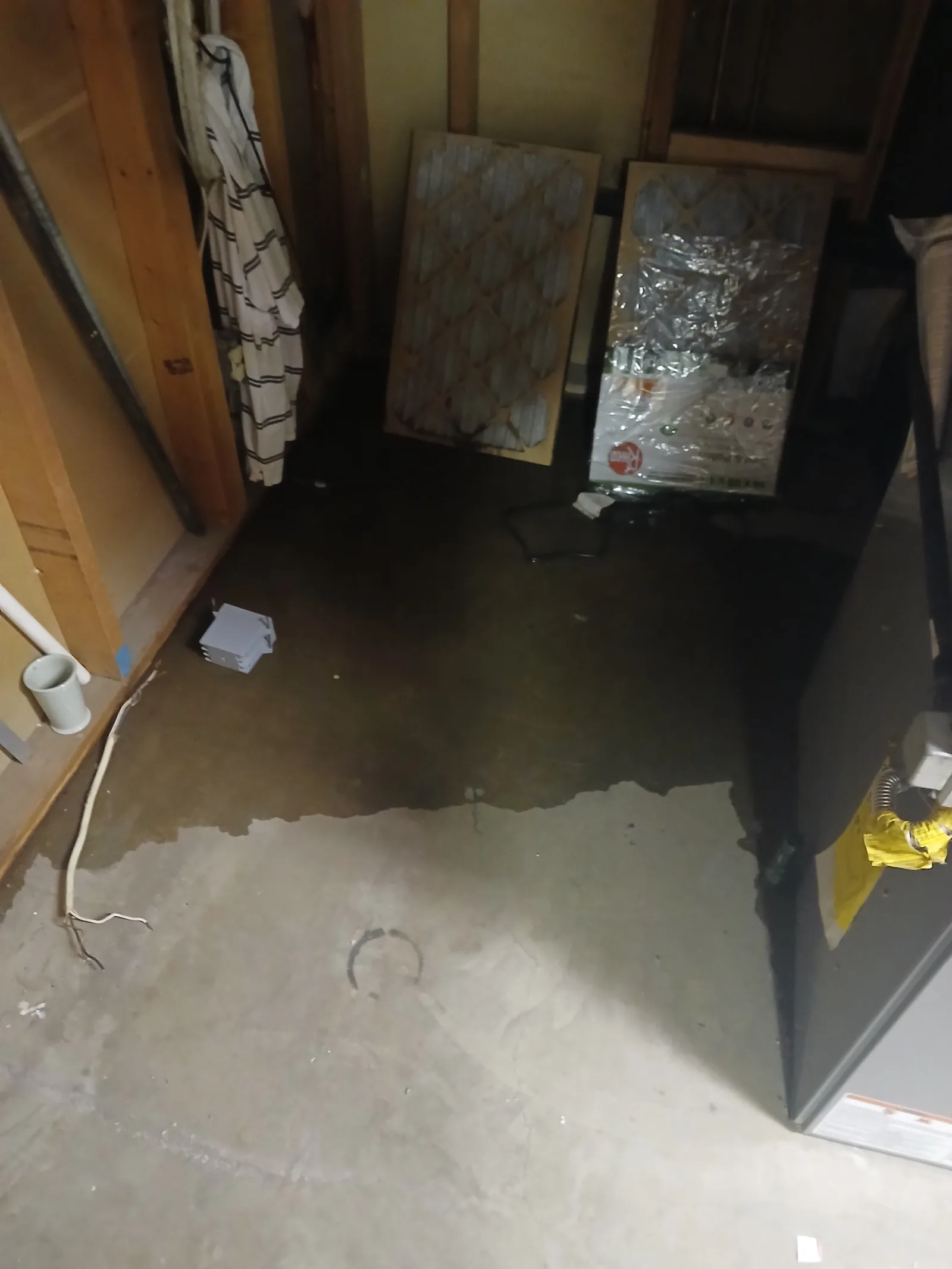 Standing water across a basement concrete floor near the water heater after a supply line failure
