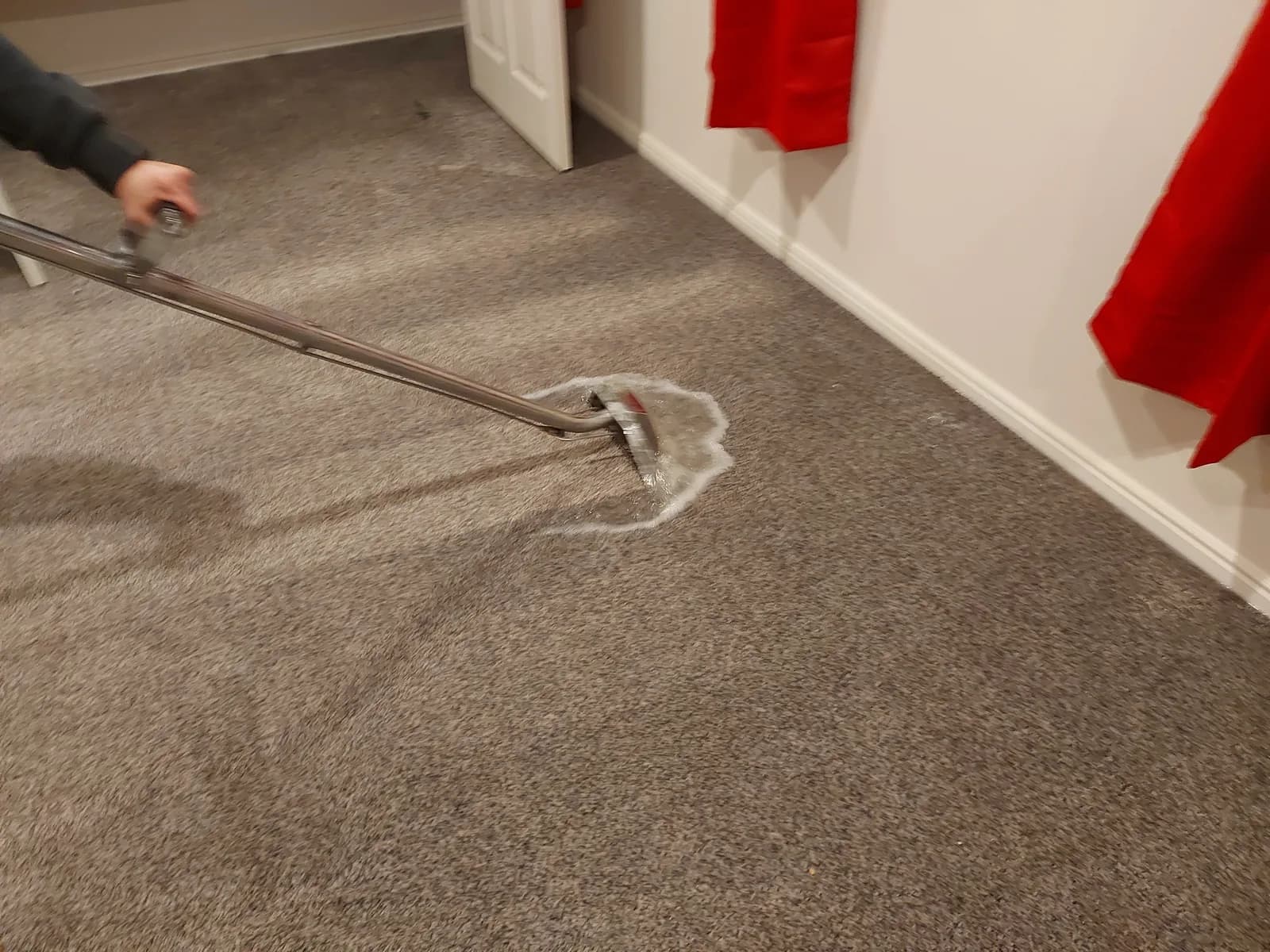 Advanced Restoration technician extracting water from soaked carpet with a commercial extraction wand